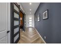 Modern hallway with herringbone floors and barn-style doors at 22034 N 59Th Pl, Phoenix, AZ 85054