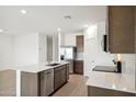 Modern kitchen with island, stainless steel appliances, and white quartz countertops at 25350 W Sunland Ave, Buckeye, AZ 85326