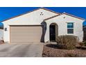 White single story home with a tan garage door and landscaping at 35170 W La Paz St, Maricopa, AZ 85138