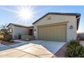 Two-car garage with light-colored doors and desert landscaping at 42085 W Morning Glory Way, Maricopa, AZ 85138