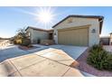 Two-car garage with light-colored doors and desert landscaping at 42085 W Morning Glory Way, Maricopa, AZ 85138