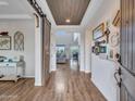 Bright entryway with wood-look floors and barn door at 44622 N Sonoran Arroyo Ln, New River, AZ 85087