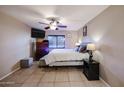 Spacious bedroom with ceiling fan, dresser, and large TV at 4539 W Mclellan Rd, Glendale, AZ 85301