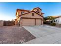 Two-story house with a three-car garage and desert landscaping at 494 S 220Th Ln, Buckeye, AZ 85326