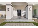 Covered entryway with gray tile flooring and modern lighting at 6105 N 174Th Ave, Waddell, AZ 85355