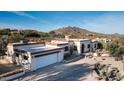 Aerial view of a single-story home with a large driveway and desert landscaping at 7957 E Cave Creek Rd, Carefree, AZ 85377