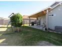 Covered patio, grassy area, and playground at 8828 E Des Moines St, Mesa, AZ 85207