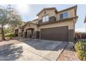 Two-story house with a brown garage door and gravel driveway at 9420 S 35Th Gln, Laveen, AZ 85339