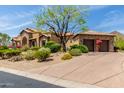 Impeccably designed home showcasing a two-car garage and beautifully maintained landscaping at 14216 E Desert Cove Ave, Scottsdale, AZ 85259