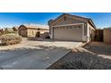 Two-car garage with a long driveway and desert landscaping at 41517 N Ranch Dr, San Tan Valley, AZ 85140