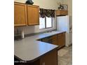 L-shaped kitchen with wood cabinets and gray countertops at 610 N Piedra --, Mesa, AZ 85207