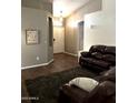 Living room with hardwood floors and a brown leather couch at 610 N Piedra --, Mesa, AZ 85207