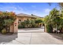 Gated estate entrance with lush landscaping and driveway at 66 Biltmore Est, Phoenix, AZ 85016