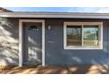 Gray front door with a window and white trim at 13428 N 36Th Pl, Phoenix, AZ 85032