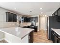 Modern kitchen with dark cabinetry, white countertops, and stainless steel appliances at 15550 N Frank Lloyd Wright Blvd # 1057, Scottsdale, AZ 85260