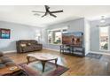 Living room featuring hardwood floors, comfortable seating, and a large TV at 17027 N 95Th Dr, Sun City, AZ 85373