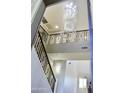 Elegant staircase with wrought iron railing and crystal chandelier at 23306 N 40Th Pl, Phoenix, AZ 85050