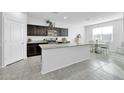 Spacious kitchen with island, dark cabinets, and granite countertops at 36085 W Prado St, Maricopa, AZ 85138