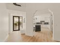 Elegant entryway with view into kitchen, featuring white walls and hardwood floors at 5101 N Casa Blanca Dr # 301, Paradise Valley, AZ 85253