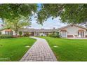 Charming ranch house with a brick pathway, lush lawn, and mature trees at 5801 E Exeter Blvd, Phoenix, AZ 85018