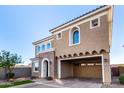 Tan two-story house with arched windows and a two-car garage at 653 N Abalone Dr, Gilbert, AZ 85233