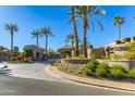 Gated community entrance with palm trees and landscaping at 7878 E Gainey Ranch Rd # 3, Scottsdale, AZ 85258