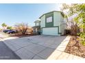 Two-story house with a green facade and attached garage, parked cars visible at 8631 W Monte Vista Rd, Phoenix, AZ 85037