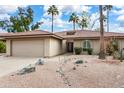 Tan house with tile roof, two-car garage, and desert landscaping at 10009 E Michigan Ave, Sun Lakes, AZ 85248