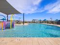 Community pool with a water playground and lounge chairs at 16074 W Prickly Pear Trl, Surprise, AZ 85387