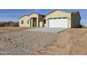 Tan single-story house with a two-car garage and gravel driveway at 33406 W Campbell Ave, Tonopah, AZ 85354