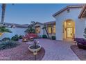 Brick-paved courtyard with seating area and lush landscaping near the home entrance at 3604 N 162Nd Ave, Goodyear, AZ 85395