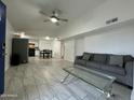 Bright living room with tile floors, sofa, and view into kitchen at 4124 N 105Th Ln, Phoenix, AZ 85037