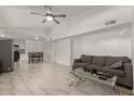 Open-concept living room featuring tile floors, neutral paint, ceiling fan, and flows into the dining area at 4124 N 105Th Ln, Phoenix, AZ 85037