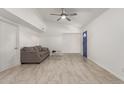 Bright living room featuring tile floors, neutral paint, ceiling fan, and blue front door at 4124 N 105Th Ln, Phoenix, AZ 85037