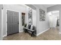 Inviting entryway with gray door, bench, and picture gallery at 6910 S 26Th Ln, Phoenix, AZ 85041