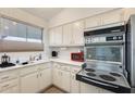 Galley kitchen with stainless steel appliances and white cabinets at 10807 N Fairway W Ct # 212, Sun City, AZ 85351