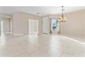 Spacious living area featuring tile floors, large windows, and a stylish chandelier at 1242 E Bartlett Way, Chandler, AZ 85249