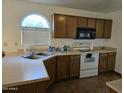 Galley kitchen with wood cabinets and a double sink at 1244 S Portland Ave, Gilbert, AZ 85296