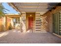 Covered entryway with red door and brick columns at 17730 W Redwood Ln, Goodyear, AZ 85338