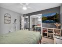 Main bedroom with a green duvet, mirrored closet doors and a large TV at 2087 E 10Th St, Tempe, AZ 85281