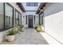 Private courtyard entry with a modern dark brown front door and potted plants at 21961 E Via De Arboles St, Queen Creek, AZ 85142