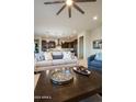 Open-concept living room featuring a plush sofa, modern ceiling fan, and seamless flow into the kitchen at 22665 E Stacey Rd, Queen Creek, AZ 85142