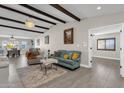 Open concept living area with hardwood floors, exposed beams, and views into dining area at 2366 E Becker Ln, Phoenix, AZ 85028