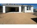 Unfinished home's exterior with a large garage door and sandy landscaping at 2446 E Spur Dr, San Tan Valley, AZ 85140