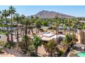 Aerial view of house, pool, and surrounding landscape with mountain view at 3801 N 64Th St, Scottsdale, AZ 85251