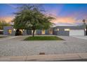 Gray stucco house with mature tree and well manicured lawn at 5429 E Bloomfield Rd, Scottsdale, AZ 85254