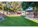 Landscaped backyard with a sparkling pool and patio cover at 7132 W Villa Chula --, Glendale, AZ 85310