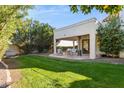 Relaxing backyard patio with seating area, grill, and grassy lawn at 8008 E Del Rubi Dr, Scottsdale, AZ 85258