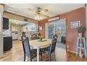 Cozy dining area featuring hardwood floors and a ceiling fan, seamlessly connecting to the kitchen and outdoor patio at 4758 E Dragoon Ave, Mesa, AZ 85206