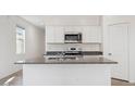 Bright kitchen features white cabinets, granite countertops, stainless steel appliances, and a center island at 5162 E Umber Rd, San Tan Valley, AZ 85143